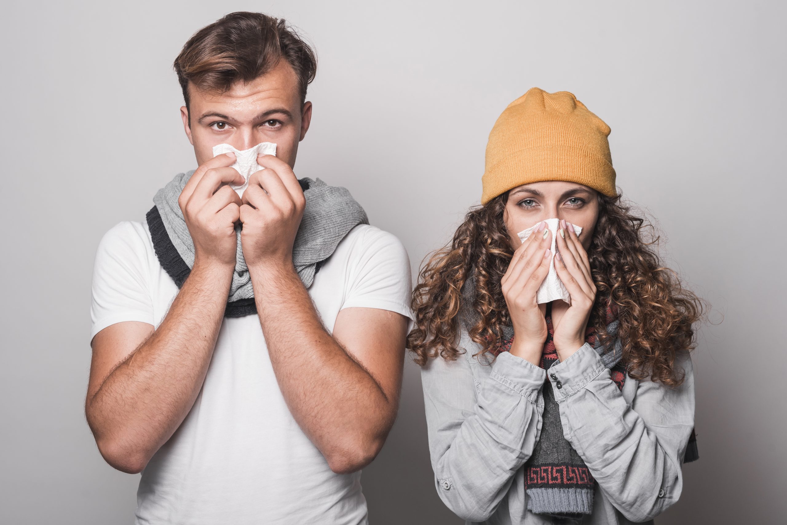 Man en vrouw verkouden. Ze snuiten hun neus.