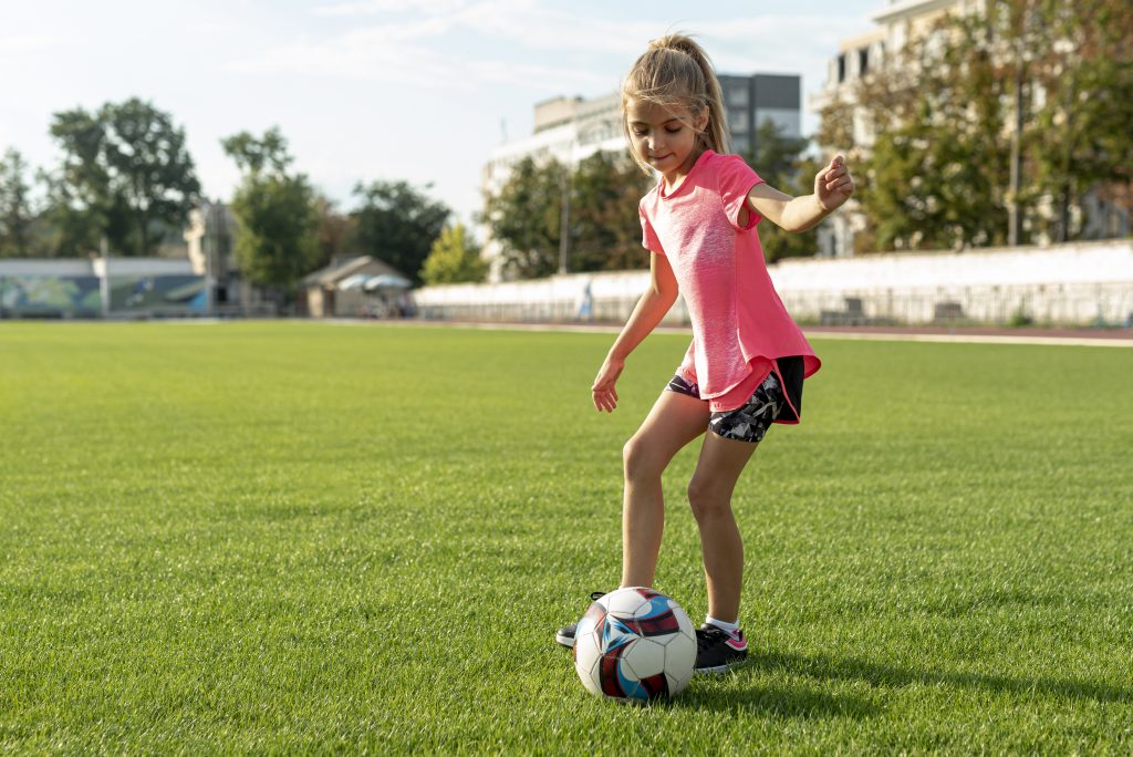 girl-with-pink-t-shirt-playing-football